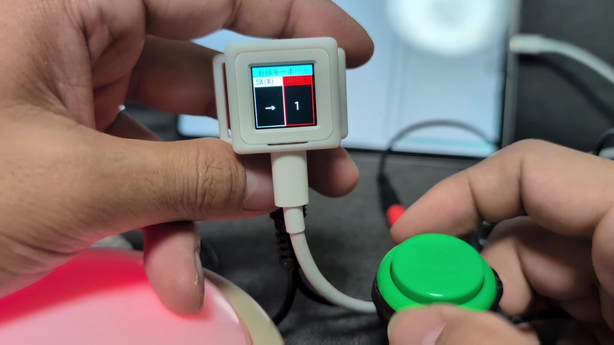 M3キューブの画面に割り当てキーが表示され、緑のスイッチで操作している様子