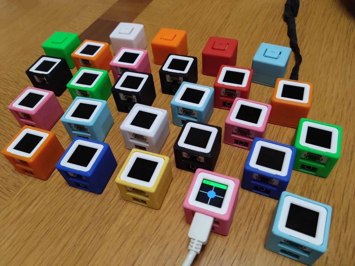 カラフルなM3キューブが机いっぱいに並んだ、第一弾の量産製作の様子
