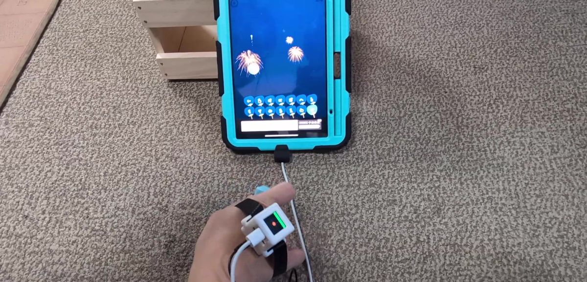 手に取り付けたM3キューブを傾けて、タブレットの画面カーソルを動かしている様子
