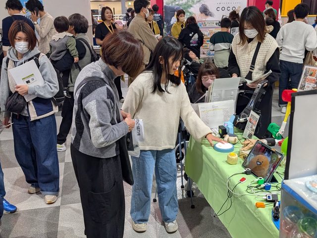 支援者が機器に触れるようす